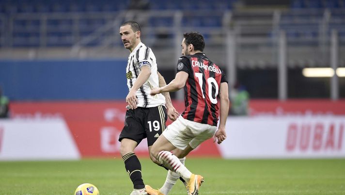 MILAN, ITALY - JANUARY 06: Leonardo Bonucci of Juventus competes for the ball with Hakan Calhanoglu of AC Milan during the Serie A match between AC Milan and Juventus at Stadio Giuseppe Meazza on January 06, 2021 in Milan, Italy. Sporting stadiums around Italy remain under strict restrictions due to the Coronavirus Pandemic as Government social distancing laws prohibit fans inside venues resulting in games being played behind closed doors. (Photo by Daniele Badolato - Juventus FC/Juventus FC via Getty Images) MILAN, ITALY - JANUARY 06: Leonardo Bonucci of Juventus competes for the ball with Hakan Calhanoglu of AC Milan during the Serie A match between AC Milan and Juventus at Stadio Giuseppe Meazza on January 06, 2021 in Milan, Italy. Sporting stadiums around Italy remain under strict restrictions due to the Coronavirus Pandemic as Government social distancing laws prohibit fans inside venues resulting in games being played behind closed doors. (Photo by Daniele Badolato - Juventus FC/Juventus FC via Getty Images)