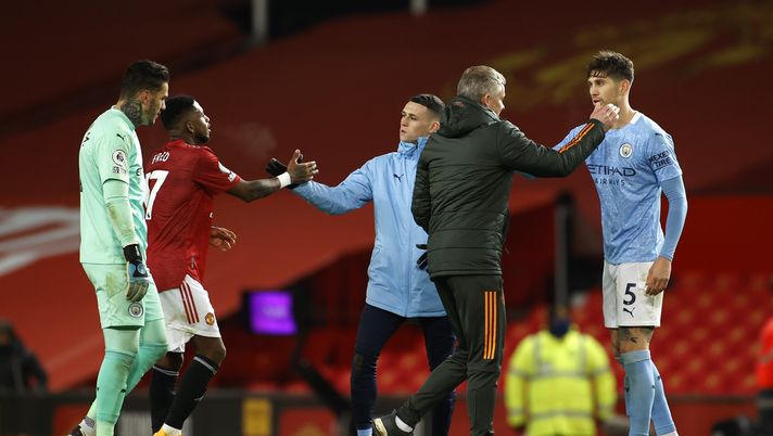 MANCHESTER, ENGLAND - DECEMBER 12: Ole Gunnar Solskjaer, Manager of Manchester United and Fred shake hands with Ederson, John Stones and Phil Foden of Manchester City after the Premier League match between Manchester United and Manchester City at Old Trafford on December 12, 2020 in Manchester, England. The match will be played without fans, behind closed doors as a Covid-19 precaution. (Photo by Phil Noble - Pool/Getty Images) MANCHESTER, ENGLAND - DECEMBER 12: Ole Gunnar Solskjaer, Manager of Manchester United and Fred shake hands with Ederson, John Stones and Phil Foden of Manchester City after the Premier League match between Manchester United and Manchester City at Old Trafford on December 12, 2020 in Manchester, England. The match will be played without fans, behind closed doors as a Covid-19 precaution. (Photo by Phil Noble - Pool/Getty Images)