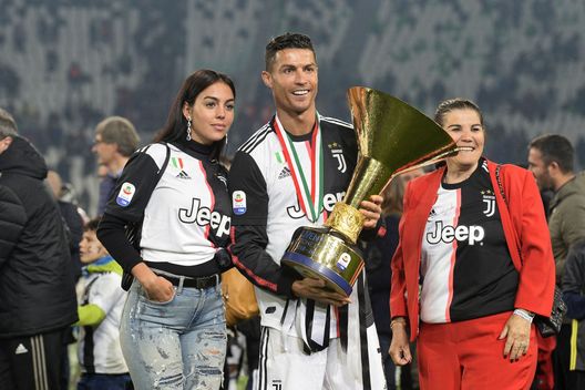 TURIN, ITALY - MAY 19: Cristiano Ronaldo of Juventus with his mother Maria Dolores Aveiro and girlfriend Georgina Rodriguez celebrates with the trophy after winning the Serie A Championship 2018-2019 (8th title in a row) at the end of the Serie A match between Juventus and Atalanta BC on May 19, 2019 in Turin, Italy. (Photo by Filippo Alfero - Juventus FC/Juventus FC via Getty Images) TURIN, ITALY - MAY 19: Cristiano Ronaldo of Juventus with his mother Maria Dolores Aveiro and girlfriend Georgina Rodriguez celebrates with the trophy after winning the Serie A Championship 2018-2019 (8th title in a row) at the end of the Serie A match between Juventus and Atalanta BC on May 19, 2019 in Turin, Italy. (Photo by Filippo Alfero - Juventus FC/Juventus FC via Getty Images)