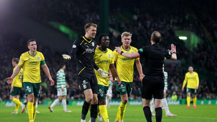 GLASGOW, SCOTLAND - JANUARY 17: Matt Macey, Josh Doig and Rocky Bushiri of Hibernian argue with referee Willie Collum after he awarded a penalty to Celtic during the Cinch Scottish Premiership match between Celtic FC and Hibernian FC at on January 17, 2022 in Glasgow, Scotland. (Photo by Ian MacNicol/Getty Images)Collu L'HIBERNIAN PASTICCIA CON I CARTELLINI