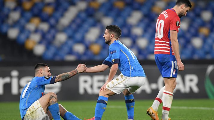 NAPLES, ITALY - FEBRUARY 25: Dries Mertens of SSC Napoli helps Matteo Politano of SSC Napoli to his feet during the UEFA Europa League Round of 32 match between SSC Napoli and Granada CF at Stadio Diego Armando Maradona on February 25, 2021 in Naples, Italy. Sporting stadiums around Italy remain under strict restrictions due to the Coronavirus Pandemic as Government social distancing laws prohibit fans inside venues resulting in games being played behind closed doors. (Photo by Francesco Pecoraro/Getty Images) 