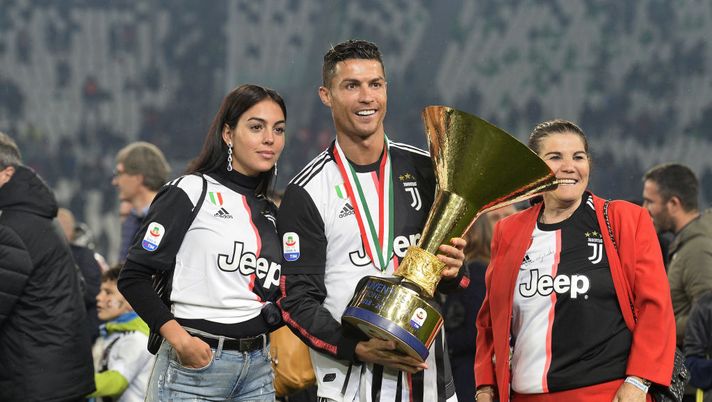 TURIN, ITALY - MAY 19: Cristiano Ronaldo of Juventus with his mother Maria Dolores Aveiro and girlfriend Georgina Rodriguez celebrates with the trophy after winning the Serie A Championship 2018-2019 (8th title in a row) at the end of the Serie A match between Juventus and Atalanta BC on May 19, 2019 in Turin, Italy. (Photo by Filippo Alfero - Juventus FC/Juventus FC via Getty Images) TURIN, ITALY - MAY 19: Cristiano Ronaldo of Juventus with his mother Maria Dolores Aveiro and girlfriend Georgina Rodriguez celebrates with the trophy after winning the Serie A Championship 2018-2019 (8th title in a row) at the end of the Serie A match between Juventus and Atalanta BC on May 19, 2019 in Turin, Italy. (Photo by Filippo Alfero - Juventus FC/Juventus FC via Getty Images)