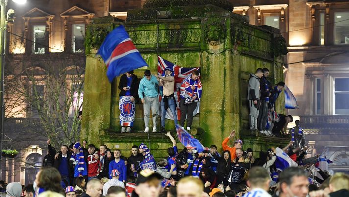 GLASGOW, SCOTLAND - MARCH 07: Fans are seen on a monument in George Square as they celebrate their team winning the Scottish Premiership title on March 07, 2021 in Glasgow, Scotland. (Photo by Mark Runnacles/Getty Images) 