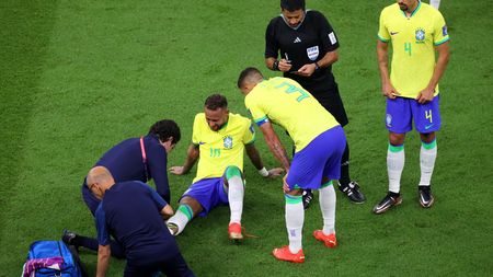 LUSAIL CITY, QATAR - NOVEMBER 24: Neymar of Brazil is attended to by medical staff during the FIFA World Cup Qatar 2022 Group G match between Brazil and Serbia at Lusail Stadium on November 24, 2022 in Lusail City, Qatar. (Photo by Michael Steele/Getty Images)