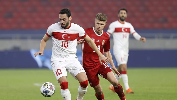 BUDAPEST, HUNGARY - NOVEMBER 18: Hakan Calhanoglu of Turkey is challenged by David Siger of Hungary during the UEFA Nations League group stage match between Hungary and Turkey at Puskas Arena on November 18, 2020 in Budapest, Hungary. Football Stadiums around Europe remain empty due to the Coronavirus Pandemic as Government social distancing laws prohibit fans inside venues resulting in fixtures being played behind closed doors. (Photo by Laszlo Szirtesi/Getty Images) BUDAPEST, HUNGARY - NOVEMBER 18: Hakan Calhanoglu of Turkey is challenged by David Siger of Hungary during the UEFA Nations League group stage match between Hungary and Turkey at Puskas Arena on November 18, 2020 in Budapest, Hungary. Football Stadiums around Europe remain empty due to the Coronavirus Pandemic as Government social distancing laws prohibit fans inside venues resulting in fixtures being played behind closed doors. (Photo by Laszlo Szirtesi/Getty Images)