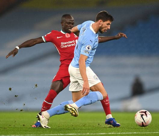 MANCHESTER, ENGLAND - NOVEMBER 08: Ruben Dias of Manchester City is challenged by Sadio Mane of Liverpool during the Premier League match between Manchester City and Liverpool at Etihad Stadium on November 08, 2020 in Manchester, England. Sporting stadiums around the UK remain under strict restrictions due to the Coronavirus Pandemic as Government social distancing laws prohibit fans inside venues resulting in games being played behind closed doors. (Photo by Shaun Botterill/Getty Images) MANCHESTER, ENGLAND - NOVEMBER 08: Ruben Dias of Manchester City is challenged by Sadio Mane of Liverpool during the Premier League match between Manchester City and Liverpool at Etihad Stadium on November 08, 2020 in Manchester, England. Sporting stadiums around the UK remain under strict restrictions due to the Coronavirus Pandemic as Government social distancing laws prohibit fans inside venues resulting in games being played behind closed doors. (Photo by Shaun Botterill/Getty Images)