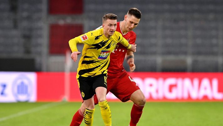 MUNICH, GERMANY - MARCH 06: Marco Reus of Borussia Dortmund holds off Niklas Suele of FC Bayern Muenchen during the Bundesliga match between FC Bayern Muenchen and Borussia Dortmund at Allianz Arena on March 06, 2021 in Munich, Germany. Sporting stadiums around Germany remain under strict restrictions due to the Coronavirus Pandemic as Government social distancing laws prohibit fans inside venues resulting in games being played behind closed doors. (Photo by Sebastian Widmann/Getty Images) MUNICH, GERMANY - MARCH 06: Marco Reus of Borussia Dortmund holds off Niklas Suele of FC Bayern Muenchen during the Bundesliga match between FC Bayern Muenchen and Borussia Dortmund at Allianz Arena on March 06, 2021 in Munich, Germany. Sporting stadiums around Germany remain under strict restrictions due to the Coronavirus Pandemic as Government social distancing laws prohibit fans inside venues resulting in games being played behind closed doors. (Photo by Sebastian Widmann/Getty Images)
