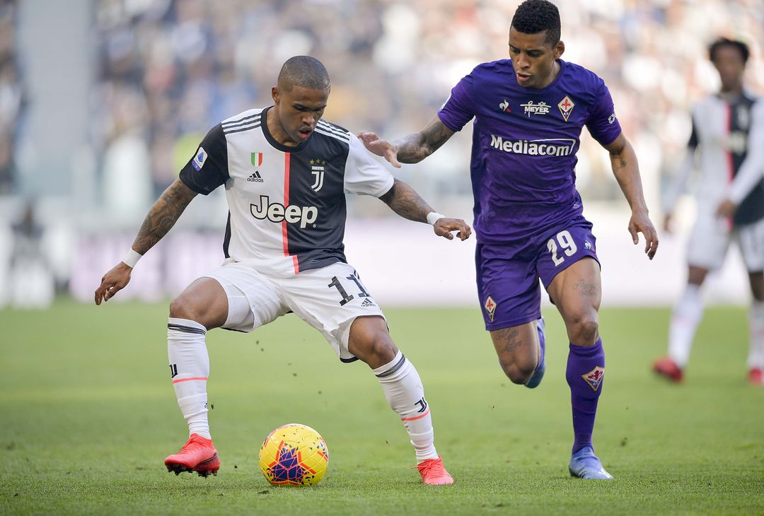  TURIN, ITALY - FEBRUARY 02:  Douglas Costa of Juventus competes for the ball with Henrique Dalbert of ACF Fiorentina during the Serie A match between Juventus and  ACF Fiorentina at Allianz Stadium on February 2, 2020 in Turin, Italy.  (Photo by Daniele Badolato - Juventus FC/Juventus FC via Getty Images)  