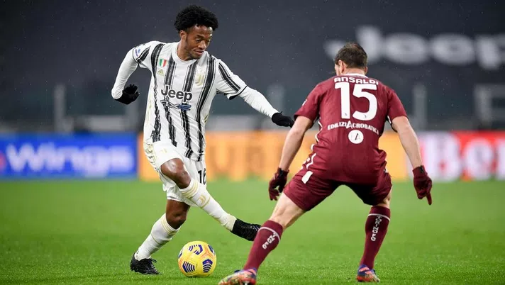 TURIN, ITALY - DECEMBER 05: Juan Cuadrado of Juventus competes for the ball with Cristian Daniel Ansaldi of Torino FC during the Serie A match between Juventus and Torino FC at Allianz Stadium on December 05, 2020 in Turin, Italy. (Photo by Daniele Badolato - Juventus FC/Juventus FC via Getty Images)