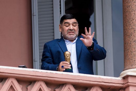 BUENOS AIRES, ARGENTINA - DECEMBER 26: Former Argentinian legend and current coach of Gimnasia y Esgrima La Plata Diego Maradona gestures with a small replica of the FIFA World Cup trophy at the balcony of Government house after a meeting with President of Argentina Alberto Fernandez at Casa Rosada on December 26, 2019 in Buenos Aires, Argentina. (Photo by Ricardo Ceppi/Getty Images) BUENOS AIRES, ARGENTINA - DECEMBER 26: Former Argentinian legend and current coach of Gimnasia y Esgrima La Plata Diego Maradona gestures with a small replica of the FIFA World Cup trophy at the balcony of Government house after a meeting with President of Argentina Alberto Fernandez at Casa Rosada on December 26, 2019 in Buenos Aires, Argentina. (Photo by Ricardo Ceppi/Getty Images)