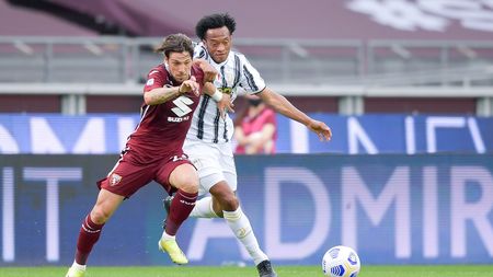 TURIN, ITALY - APRIL 03: Juan Cuadrado of Juventus fights for the ball against Simone Verdi of Torino FC during the Serie A match between Torino FC and Juventus at Stadio Olimpico di Torino on April 03, 2021 in Turin, Italy. Sporting stadiums around Italy remain under strict restrictions due to the Coronavirus Pandemic as Government social distancing laws prohibit fans inside venues resulting in games being played behind closed doors. (Photo by Daniele Badolato - Juventus FC/Juventus FC via Getty Images)
