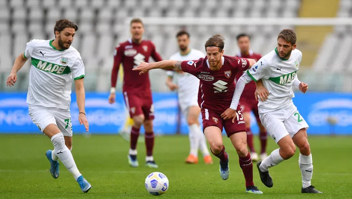 TURIN, ITALY - MARCH 17: Cristian Ansaldi of Torino F.C. is challenged by Domenico Berardi and Manuel Locatelli of Sassuolo during the Serie A match between Torino FC and US Sassuolo at Stadio Olimpico di Torino on March 17, 2021 in Turin, Italy. Sporting stadiums around Italy remain under strict restrictions due to the Coronavirus Pandemic as Government social distancing laws prohibit fans inside venues resulting in games being played behind closed doors. (Photo by Valerio Pennicino/Getty Images)