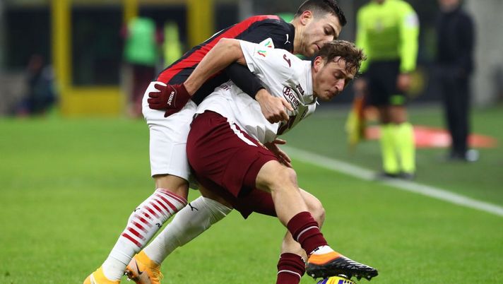 MILAN, ITALY - JANUARY 12: Mergim Vojvoda of Torino F.C. is challenged by Diogo Dalot of A.C. Milan during the Coppa Italia match between AC Milan and Torino FC at Stadio Giuseppe Meazza on January 12, 2021 in Milan, Italy. Sporting stadiums around Italy remain under strict restrictions due to the Coronavirus Pandemic as Government social distancing laws prohibit fans inside venues resulting in games being played behind closed doors. (Photo by Marco Luzzani/Getty Images) 