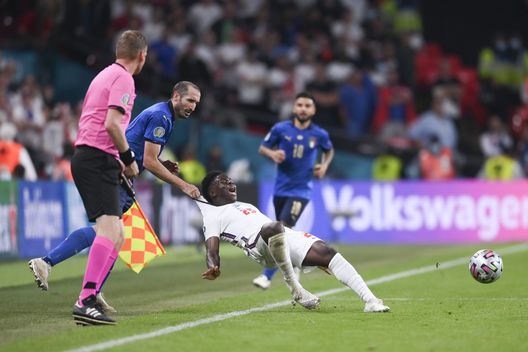 LONDON, ENGLAND - JULY 11: Bukayo Saka of England is fouled by Giorgio Chiellini of Italy during the UEFA Euro 2020 Championship Final between Italy and England at Wembley Stadium on July 11, 2021 in London, England. (Photo by Laurence Griffiths/Getty Images) LONDON, ENGLAND - JULY 11: Bukayo Saka of England is fouled by Giorgio Chiellini of Italy during the UEFA Euro 2020 Championship Final between Italy and England at Wembley Stadium on July 11, 2021 in London, England. (Photo by Laurence Griffiths/Getty Images)