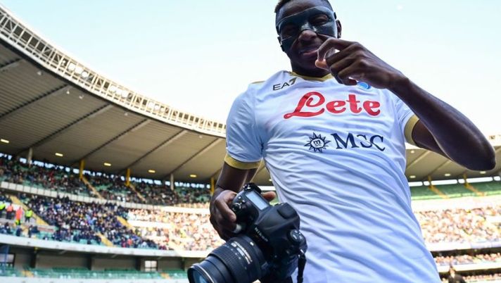 Napoli's Nigerian forward Victor Osimhen holds a photographer's camera as he celebrates after scoring his second goal during the Italian Serie A football match between Hellas Verona and Napoli on March 13, 2022 at the Marcantonio-Bentegodi stadium in Verona. (Photo by MIGUEL MEDINA / AFP) (Photo by MIGUEL MEDINA/AFP via Getty Images) Napoli, con l’Atalanta senza Osimhen e non solo: tre cambi obbligati tra i titolari - immagine 1
