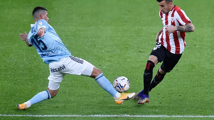 BILBAO, SPAIN - DECEMBER 04: Alex Berenguer (R) of Athletic Club is challenged by Lucas Olaza of Celta de Vigo during the La Liga Santader match between Athletic Club and RC Celta at Estadio de San Mames on December 04, 2020 in Bilbao, Spain. Sporting stadiums around Spain remain under strict restrictions due to the Coronavirus Pandemic as Government social distancing laws prohibit fans inside venues resulting in games being played behind closed doors.  (Photo by Juan Manuel Serrano Arce/Getty Images)