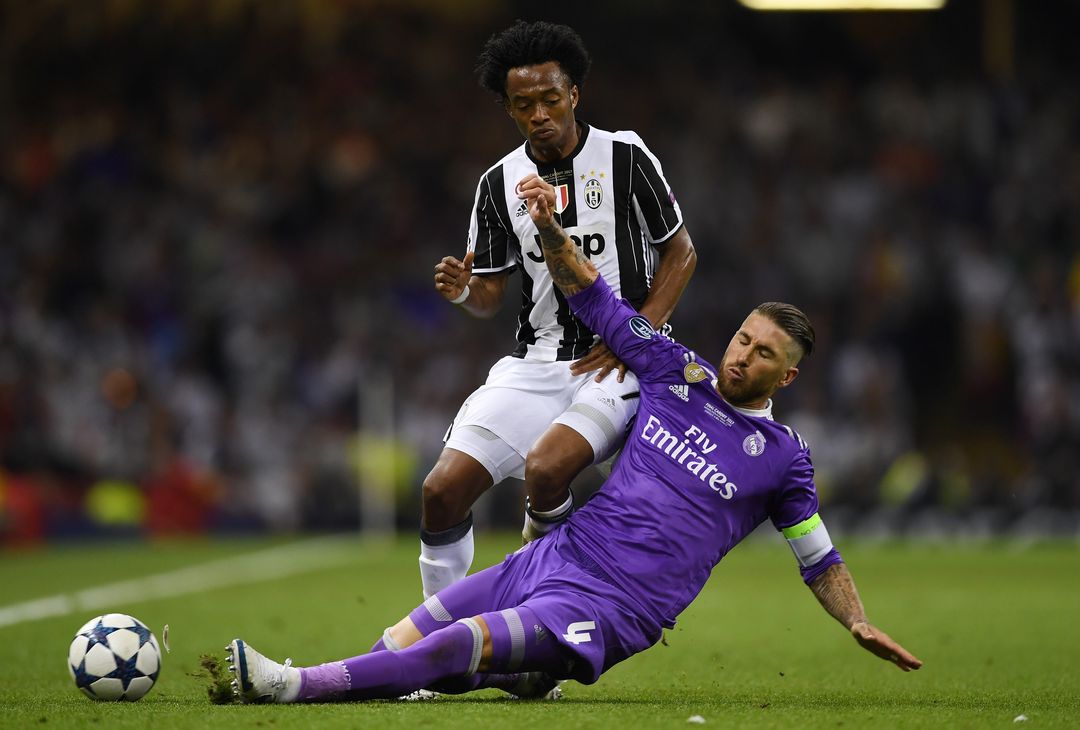  CARDIFF, WALES - JUNE 03:  Juan Cuadrado of Juventus and Sergio Ramos of Real Madrid battle for possession during the UEFA Champions League Final between Juventus and Real Madrid at National Stadium of Wales on June 3, 2017 in Cardiff, Wales.  (Photo by Shaun Botterill/Getty Images) 