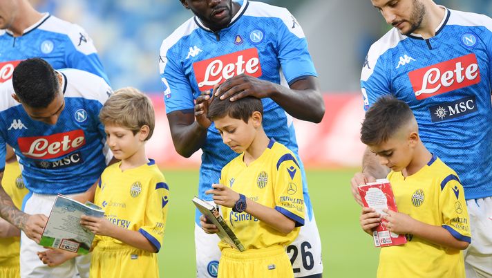 NAPLES, ITALY - OCTOBER 19: Allan, Kalidou Koulibaly and Kostantinos Manolas of SSC Napoli with some ball boys with a book in their hand for the campaign #ioleggoperchè before the Serie A match between SSC Napoli and Hellas Verona at Stadio San Paolo on October 19, 2019 in Naples, Italy. (Photo by Francesco Pecoraro/Getty Images) 