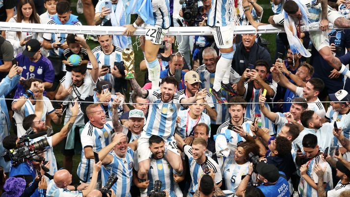 LUSAIL CITY, QATAR - DECEMBER 18: Lionel Messi of Argentina celebrates with teammates and the FIFA World Cup Qatar 2022 Winner's Trophy after the team's victory during the FIFA World Cup Qatar 2022 Final match between Argentina and France at Lusail Stadium on December 18, 2022 in Lusail City, Qatar. (Photo by Alex Pantling/Getty Images) Messi indossa un indumento caratteristico dei ricchi uomini del Qatar. È polemica - immagine 1