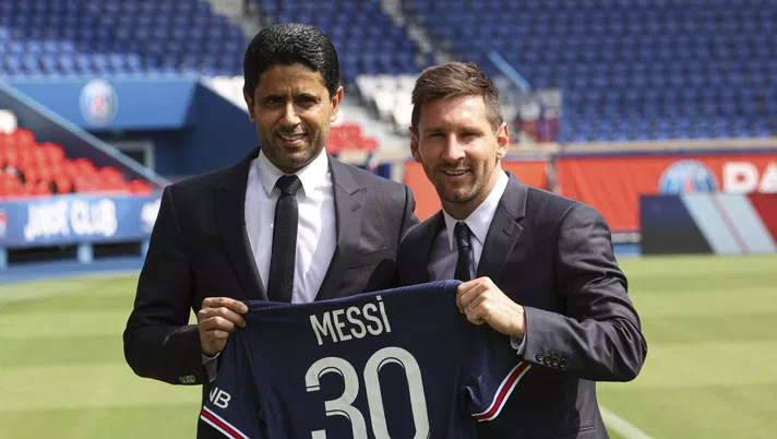 PARIS, FRANCE - AUGUST 11: Lionel Messi poses with his jersey next to President Nasser Al Khelaifi after the press conference of Paris Saint-Germain at Parc des Princes on August 11, 2021 in Paris, France. (Photo by Sebastien Muylaert/Getty Images)