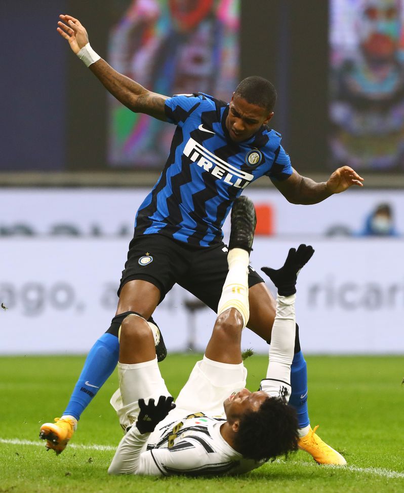 MILAN, ITALY - FEBRUARY 02: Ashley Young of Internazionale fouls Juan Cuadrado of Juventus in the penalty box which leads to a penalty during the Coppa Italia semi-final match between FC Internazionale and Juventus at Stadio Giuseppe Meazza on February 02, 2021 in Milan, Italy. Sporting stadiums around Italy remain under strict restrictions due to the Coronavirus Pandemic as Government social distancing laws prohibit fans inside venues resulting in games being played behind closed doors. (Photo by Marco Luzzani/Getty Images)