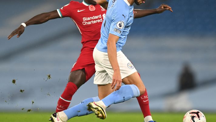 MANCHESTER, ENGLAND - NOVEMBER 08: Ruben Dias of Manchester City is challenged by Sadio Mane of Liverpool during the Premier League match between Manchester City and Liverpool at Etihad Stadium on November 08, 2020 in Manchester, England. Sporting stadiums around the UK remain under strict restrictions due to the Coronavirus Pandemic as Government social distancing laws prohibit fans inside venues resulting in games being played behind closed doors. (Photo by Shaun Botterill/Getty Images) MANCHESTER, ENGLAND - NOVEMBER 08: Ruben Dias of Manchester City is challenged by Sadio Mane of Liverpool during the Premier League match between Manchester City and Liverpool at Etihad Stadium on November 08, 2020 in Manchester, England. Sporting stadiums around the UK remain under strict restrictions due to the Coronavirus Pandemic as Government social distancing laws prohibit fans inside venues resulting in games being played behind closed doors. (Photo by Shaun Botterill/Getty Images)