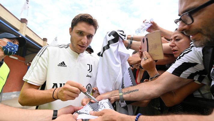 VILLAR PEROSA, ITALY - AUGUST 04: Federico Chiesa of Juventus signs autographs to Juventus fans during the Pre-Season Friendly between Juventus vs Juventus B on August 04, 2022 in Villar Perosa, Italy. (Photo by Chris Ricco - Juventus FC/Juventus FC via Getty Images) L’intercettazione: “Kulusevski-Chiesa pagati troppo. Abbiamo drogato il mercato” - immagine 1