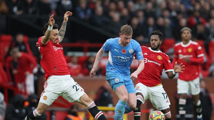 MANCHESTER, ENGLAND - NOVEMBER 06: Kevin De Bruyne of Manchester City runs with the ball from Alex Telles and Fred of Manchester United during the Premier League match between Manchester United and Manchester City at Old Trafford on November 06, 2021 in Manchester, England. (Photo by Clive Brunskill/Getty Images) MANCHESTER, ENGLAND - NOVEMBER 06: Kevin De Bruyne of Manchester City runs with the ball from Alex Telles and Fred of Manchester United during the Premier League match between Manchester United and Manchester City at Old Trafford on November 06, 2021 in Manchester, England. (Photo by Clive Brunskill/Getty Images)