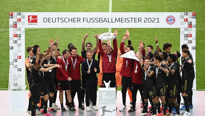 MUNICH, GERMANY - MAY 22: The FC Bayern Muenchen physio lifts the Bundesliga Meisterschale Trophy in celebration with team mates following the Bundesliga match between FC Bayern Muenchen and FC Augsburg at Allianz Arena on May 22, 2021 in Munich, Germany. After the Bavarian cabinet decided on first relaxations for outdoor events, the current Corona situation allows FC Bayern to have its last match of the season in front of 250 spectators in the Allianz Arena. Of these, 100 tickets are given to people from the health sector selected by the Ministry of Health. (Photo by Sven Hoppe - Pool/Getty Images) MUNICH, GERMANY - MAY 22: The FC Bayern Muenchen physio lifts the Bundesliga Meisterschale Trophy in celebration with team mates following the Bundesliga match between FC Bayern Muenchen and FC Augsburg at Allianz Arena on May 22, 2021 in Munich, Germany. After the Bavarian cabinet decided on first relaxations for outdoor events, the current Corona situation allows FC Bayern to have its last match of the season in front of 250 spectators in the Allianz Arena. Of these, 100 tickets are given to people from the health sector selected by the Ministry of Health. (Photo by Sven Hoppe - Pool/Getty Images)