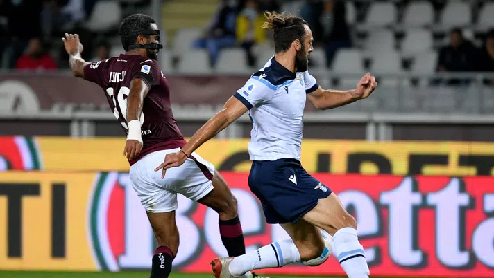 TURIN, ITALY - SEPTEMBER 23: Vedat Muriqi of SS Lazio compete for the ball with Koffi Djidji of Torino FC during the Serie A match between Torino FC v SS Lazio at Stadio Olimpico di Torino on September 23, 2021 in Turin, Italy. (Photo by Marco Rosi - SS Lazio/Getty Images)
