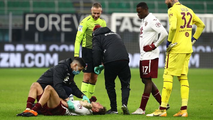 MILAN, ITALY - JANUARY 12: Mergim Vojvoda of Torino F.C. receives medical treatment as Wilfried Singo and Vanja Milinkovic-Savic of Torino F.C. look on during the Coppa Italia match between AC Milan and Torino FC at Stadio Giuseppe Meazza on January 12, 2021 in Milan, Italy. Sporting stadiums around Italy remain under strict restrictions due to the Coronavirus Pandemic as Government social distancing laws prohibit fans inside venues resulting in games being played behind closed doors. (Photo by Marco Luzzani/Getty Images) MILAN, ITALY - JANUARY 12: Mergim Vojvoda of Torino F.C. receives medical treatment as Wilfried Singo and Vanja Milinkovic-Savic of Torino F.C. look on during the Coppa Italia match between AC Milan and Torino FC at Stadio Giuseppe Meazza on January 12, 2021 in Milan, Italy. Sporting stadiums around Italy remain under strict restrictions due to the Coronavirus Pandemic as Government social distancing laws prohibit fans inside venues resulting in games being played behind closed doors. (Photo by Marco Luzzani/Getty Images)