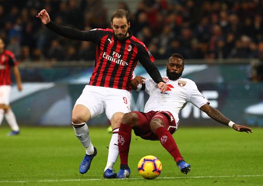  MILAN, ITALY - DECEMBER 09: Gonzalo Higuain of AC Milan competes for the ball with Nicolas Nkoulou of Torino FC during the Serie A match between AC Milan and Torino FC at Stadio Giuseppe Meazza on December 9, 2018 in Milan, Italy. (Photo by Marco Luzzani/Getty Images) 