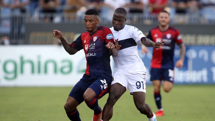 CAGLIARI, ITALY - SEPTEMBER 12: Dalbert of Cagliari and Yayah Kallon of Genoa compete for the ball during the Serie A match between Cagliari Calcio and Genoa CFC at Sardegna Arena on September 12, 2021 in Cagliari, Italy. (Photo by Enrico Locci/Getty Images) Il Verona si muove per Ilicic e non solo, Sky: “Trattativa chiusa per Kallon” - immagine 1