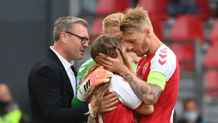 TOPSHOT - Sabrina Kvist Jensen (C), partner of Denmark's midfielder Christian Eriksen, is embraced by Denmark's defender Simon Kjaer (R) as she reacts after Eriksen collapsed during the UEFA EURO 2020 Group B football match between Denmark and Finland at the Parken Stadium in Copenhagen on June 12, 2021. (Photo by Jonathan NACKSTRAND / various sources / AFP) (Photo by JONATHAN NACKSTRAND/AFP via Getty Images) Kjaer: “Che choc, conta solo che Eriksen stia bene. Giochiamo per lui col Belgio” - immagine 1