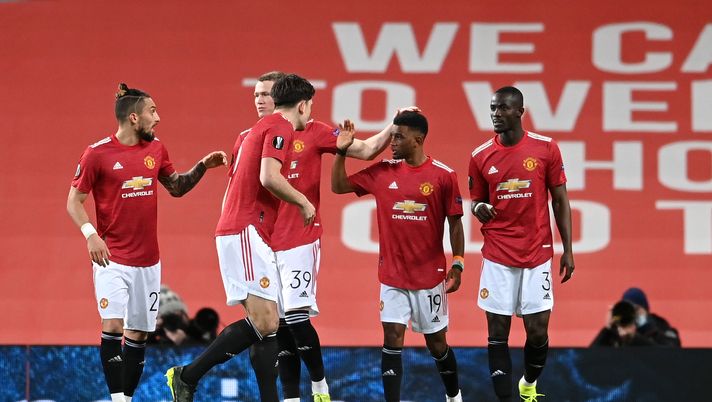 MANCHESTER, ENGLAND - MARCH 11: Amad Diallo of Manchester United celebrates with teammates Alex Telles, Scott McTominay, Harry Maguire and Eric Bailly after scoring their team's first goal during the UEFA Europa League Round of 16 First Leg match between Manchester United and A.C. Milan at Old Trafford on March 11, 2021 in Manchester, England. Sporting stadiums around the UK remain under strict restrictions due to the Coronavirus Pandemic as Government social distancing laws prohibit fans inside venues resulting in games being played behind closed doors. (Photo by Laurence Griffiths/Getty Images) MANCHESTER, ENGLAND - MARCH 11: Amad Diallo of Manchester United celebrates with teammates Alex Telles, Scott McTominay, Harry Maguire and Eric Bailly after scoring their team's first goal during the UEFA Europa League Round of 16 First Leg match between Manchester United and A.C. Milan at Old Trafford on March 11, 2021 in Manchester, England. Sporting stadiums around the UK remain under strict restrictions due to the Coronavirus Pandemic as Government social distancing laws prohibit fans inside venues resulting in games being played behind closed doors. (Photo by Laurence Griffiths/Getty Images)
