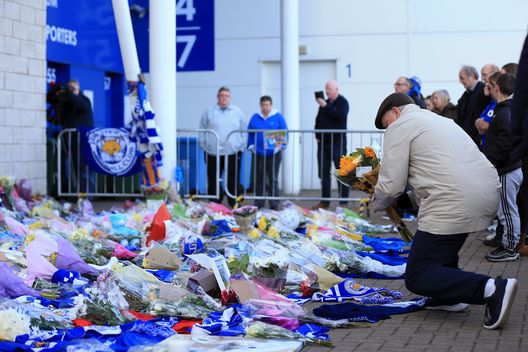  LEICESTER, ENGLAND - OCTOBER 28: Mourners arrive to pay tributes after the helicopter crash at The King Power Stadium on October 28, 2018 in Leicester, England. The owner of Leicester City Football Club, Vichai Srivaddhanaprabha, is reported to have been on the helicopter when it crashed around 8:30 the previous night. (Photo by Stephen Pond/Getty Images) 