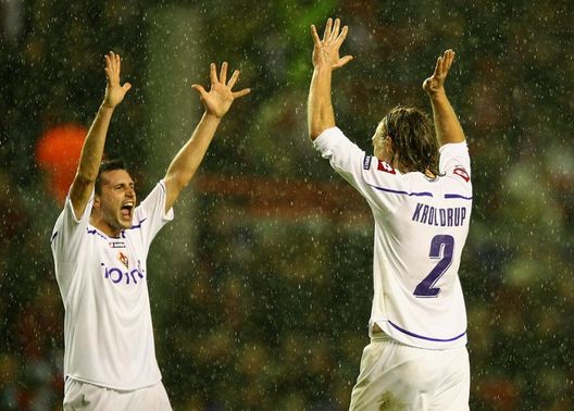 LIVERPOOL, ENGLAND - DECEMBER 09:  Manuel Pasqual of Fiorentina celebrates with team mate Per Kroldrup (R) at the end of the UEFA Champions League Group E match between Liverpool and Fiorentina at Anfield on December 9, 2009 in Liverpool, England.  (Photo by Clive Brunskill/Getty Images) 