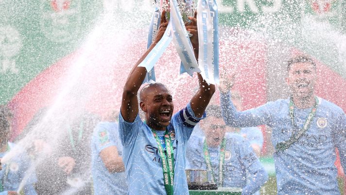 LONDON, ENGLAND - APRIL 25: Fernandinho of Manchester City lifts the Carabao Cup Trophy as his team celebrate victory after the Carabao Cup Final between Manchester City and Tottenham Hotspur at Wembley Stadium on April 25, 2021 in London, England. 8,000 fans are due to watch the game at Wembley, the most at an outdoor sporting event in the UK since the coronavirus pandemic started in March, 2020. Each team has been given an allocation of 2,000 with the remaining tickets split between local residents and NHS staff. (Photo by Clive Rose/Getty Images) LONDON, ENGLAND - APRIL 25: Fernandinho of Manchester City lifts the Carabao Cup Trophy as his team celebrate victory after the Carabao Cup Final between Manchester City and Tottenham Hotspur at Wembley Stadium on April 25, 2021 in London, England. 8,000 fans are due to watch the game at Wembley, the most at an outdoor sporting event in the UK since the coronavirus pandemic started in March, 2020. Each team has been given an allocation of 2,000 with the remaining tickets split between local residents and NHS staff. (Photo by Clive Rose/Getty Images)