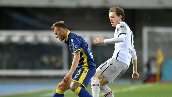 VERONA, ITALY - MAY 17: Federico Dimarco of Hellas Verona F.C. is challenged by Andreas Skov Olsen of Bologna FC during the Serie A match between Hellas Verona FC and Bologna FC at Stadio Marcantonio Bentegodi on May 17, 2021 in Verona, Italy. Sporting stadiums around Italy remain under strict restrictions due to the Coronavirus Pandemic as Government social distancing laws prohibit fans inside venues resulting in games being played behind closed doors. (Photo by Alessandro Sabattini/Getty Images) Mercato – Dijks-Standard e Skov-Bruges: la situazione - immagine 1