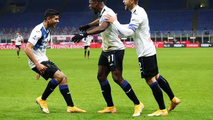 MILAN, ITALY - JANUARY 23: Duvan Zapata of Atalanta B.C. celebrates with team mates Cristian Romero (L) of Atalanta and Rafael Toloi (R) after scoring their team's third goal during the Serie A match between AC Milan and Atalanta BC at Stadio Giuseppe Meazza on January 23, 2021 in Milan, Italy. Sporting stadiums around Italy remain under strict restrictions due to the Coronavirus Pandemic as Government social distancing laws prohibit fans inside venues resulting in games being played behind closed doors. (Photo by Marco Luzzani/Getty Images)