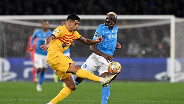 NAPLES, ITALY - FEBRUARY 21: Joao Cancelo of FC Barcelona clears the ball whilst under pressure from Victor Osimhen of SSC Napoli during the UEFA Champions League 2023/24 round of 16 first leg match between SSC Napoli and FC Barcelona at Stadio Diego Armando Maradona on February 21, 2024 in Naples, Italy. (Photo by Francesco Pecoraro/Getty Images) Osimhen-Buongiorno, duello inedito: ed entrambi sono in grande forma - immagine 1