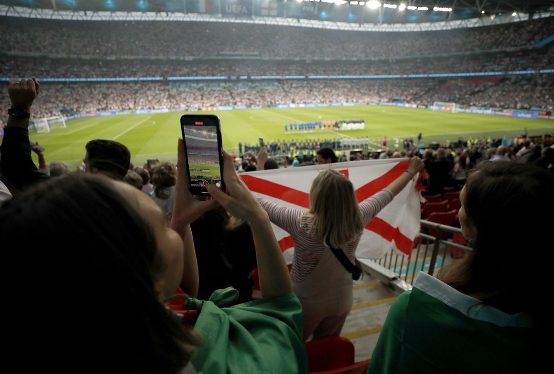  LONDON, ENGLAND - JULY 11: A fan is seen taking a photograph whilst both side's line up prior to the UEFA Euro 2020 Championship Final between Italy and England at Wembley Stadium on July 11, 2021 in London, England. (Photo by John Sibley - Pool/Getty Images)  