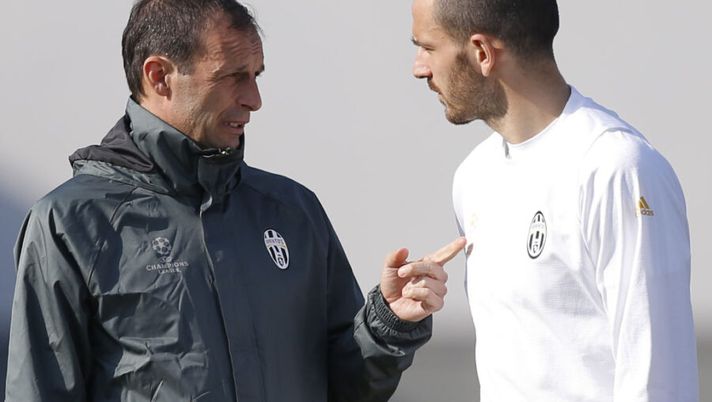 Juventus' coach Massimiliano Allegri (L) chats with Juventus' defender Leonardo Bonucci during a training session on the eve of the UEFA Champions League football match Juventus Vs FC Porto on March 13, 2017 at the 'Juventus Training Center' in Vinovo, near Turin. / AFP PHOTO / Marco BERTORELLO (Photo credit should read MARCO BERTORELLO/AFP via Getty Images) Chi sarà il capitano della Juve? Allegri: “Bonucci compra la fascia e gioca in piazza” - immagine 1