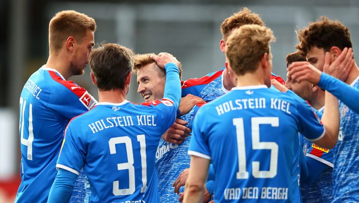 KIEL, GERMANY - MAY 07: Janni Serra of Holstein Kiel celebrates with team mates Niklas Hauptmann, Hauke Wahl and Fin Bartels after scoring his team's fourth goal during the Second Bundesliga match between Holstein Kiel and FC St. Pauli at Holstein-Stadion on May 07, 2021 in Kiel, Germany. Sporting stadiums around Germany remain under strict restrictions due to the Coronavirus Pandemic as Government social distancing laws prohibit fans inside venues resulting in games being played behind closed doors. (Photo by Martin Rose/Getty Images) KIEL, GERMANY - MAY 07: Janni Serra of Holstein Kiel celebrates with team mates Niklas Hauptmann, Hauke Wahl and Fin Bartels after scoring his team's fourth goal during the Second Bundesliga match between Holstein Kiel and FC St. Pauli at Holstein-Stadion on May 07, 2021 in Kiel, Germany. Sporting stadiums around Germany remain under strict restrictions due to the Coronavirus Pandemic as Government social distancing laws prohibit fans inside venues resulting in games being played behind closed doors. (Photo by Martin Rose/Getty Images)