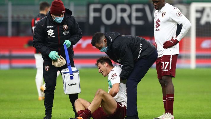MILAN, ITALY - JANUARY 12: Mergim Vojvoda of Torino F.C. receives medical treatment as Wilfried Singo of Torino F.C. looks on during the Coppa Italia match between AC Milan and Torino FC at Stadio Giuseppe Meazza on January 12, 2021 in Milan, Italy. Sporting stadiums around Italy remain under strict restrictions due to the Coronavirus Pandemic as Government social distancing laws prohibit fans inside venues resulting in games being played behind closed doors. (Photo by Marco Luzzani/Getty Images) MILAN, ITALY - JANUARY 12: Mergim Vojvoda of Torino F.C. receives medical treatment as Wilfried Singo of Torino F.C. looks on during the Coppa Italia match between AC Milan and Torino FC at Stadio Giuseppe Meazza on January 12, 2021 in Milan, Italy. Sporting stadiums around Italy remain under strict restrictions due to the Coronavirus Pandemic as Government social distancing laws prohibit fans inside venues resulting in games being played behind closed doors. (Photo by Marco Luzzani/Getty Images)
