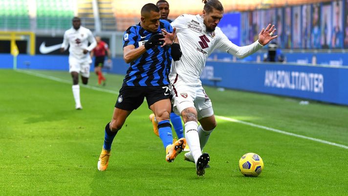 MILAN, ITALY - NOVEMBER 22: Alexis Sanchez of Inter Milan battles for possession with Lyanco of Torino during the Serie A match between FC Internazionale and Torino FC at Stadio Giuseppe Meazza on November 22, 2020 in Milan, Italy. Sporting stadiums around Italy remain under strict restrictions due to the Coronavirus Pandemic as Government social distancing laws prohibit fans inside venues resulting in games being played behind closed doors. (Photo by Valerio Pennicino/Getty Images) 