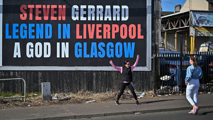 GLASGOW, SCOTLAND - MARCH 21: A woman reacts as she walks past a billboard near to Celtic park as as arch rivals Celtic and Rangers meet in the Old Firm derby fixture on March 21, 2021 in Glasgow, Scotland. The fixture at Celtic Park was at risk after Rangers fans breached lockdown to celebrate their team's title win. (Photo by Jeff J Mitchell/Getty Images) GLASGOW, SCOTLAND - MARCH 21: A woman reacts as she walks past a billboard near to Celtic park as as arch rivals Celtic and Rangers meet in the Old Firm derby fixture on March 21, 2021 in Glasgow, Scotland. The fixture at Celtic Park was at risk after Rangers fans breached lockdown to celebrate their team's title win. (Photo by Jeff J Mitchell/Getty Images)