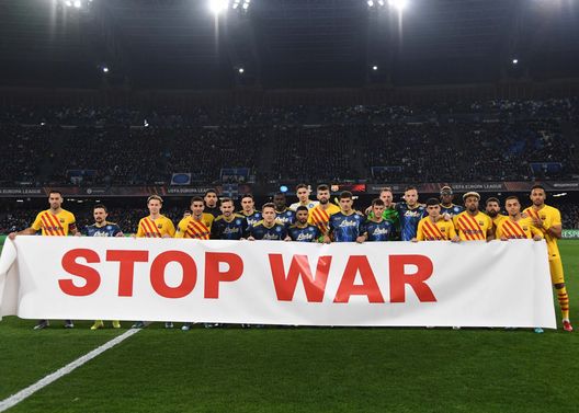 NAPLES, ITALY - FEBRUARY 24: Team members of Napoli and Barcelona hold a banner that reads, "Stop War" during the UEFA Europa League Knockout Round Play-Offs Leg Two match between SSC Napoli and FC Barcelona at Stadio Diego Armando Maradona on February 24, 2022 in Naples, Italy. (Photo by SSC NAPOLI/SSC NAPOLI via Getty Images) Striscione no WAR, nessuna immagine in tv per non coinvolgere l’arbitro di Napoli – Barcellona - immagine 1