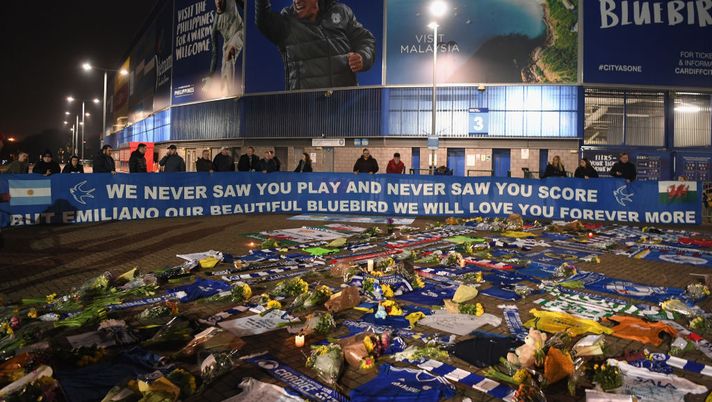 CARDIFF, WALES - JANUARY 24: Cardiff City fans unveil a flag in front of tributes for their £15 Million forward Emiliano Sala after the search for the missing Footballer and pilot was called off after rescuers failed to find their plane at Cardiff City Stadium on January 24, 2019 in Cardiff, Wales. (Photo by Stu Forster/Getty Images) CARDIFF, WALES - JANUARY 24: Cardiff City fans unveil a flag in front of tributes for their £15 Million forward Emiliano Sala after the search for the missing Footballer and pilot was called off after rescuers failed to find their plane at Cardiff City Stadium on January 24, 2019 in Cardiff, Wales. (Photo by Stu Forster/Getty Images)