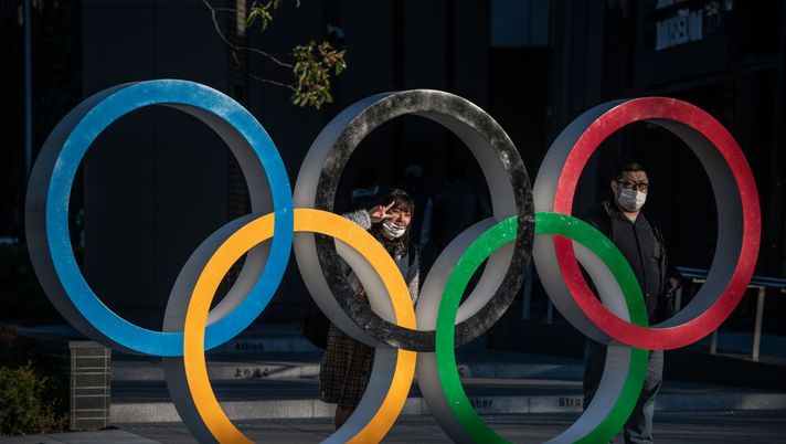 TOKYO, JAPAN - MARCH 24: People wearing face masks pose for photographs next to Olympic Rings on March 24, 2020 in Tokyo, Japan. Although an official decision is yet to be announced, International Olympic Committee member Dick Pound has said the Tokyo 2020 Olympic Games will be postponed by one year because of the Covid-19 coronavirus after the chairman of the British Olympic Association said Great Britain would be unlikely to send a team to Tokyo this summer while Australia and Canada also said they will not compete as the global Covid-19 coronavirus pandemic that has so far seen over 380,000 infections around the world forces countries to take drastic measures to protect their populations. (Photo by Carl Court/Getty Images) TOKYO, JAPAN - MARCH 24: People wearing face masks pose for photographs next to Olympic Rings on March 24, 2020 in Tokyo, Japan. Although an official decision is yet to be announced, International Olympic Committee member Dick Pound has said the Tokyo 2020 Olympic Games will be postponed by one year because of the Covid-19 coronavirus after the chairman of the British Olympic Association said Great Britain would be unlikely to send a team to Tokyo this summer while Australia and Canada also said they will not compete as the global Covid-19 coronavirus pandemic that has so far seen over 380,000 infections around the world forces countries to take drastic measures to protect their populations. (Photo by Carl Court/Getty Images)